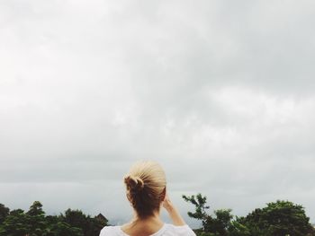 Rear view of woman against cloudy sky
