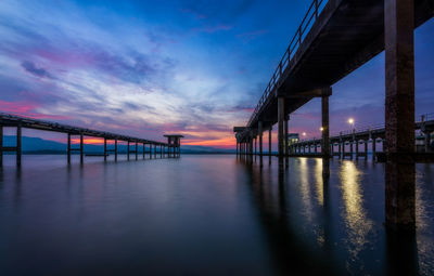 Pier over sea against sky during sunset