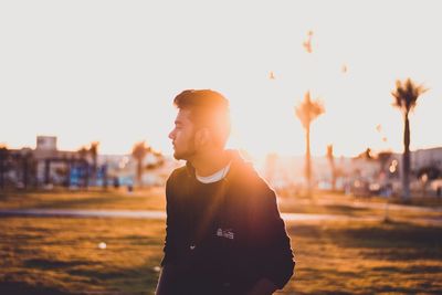 Young man standing against sky at night