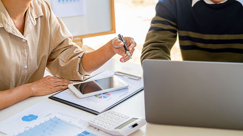 Midsection of woman using laptop on table