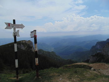 View of cross sign on mountain against sky