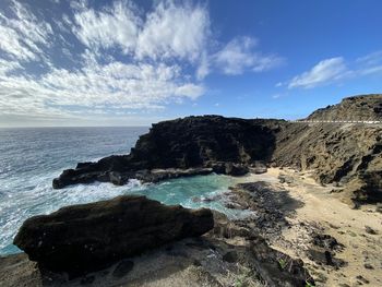 Scenic view of rocks on beach against sky