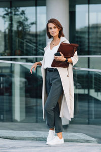 Side view of young woman standing in city