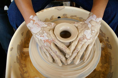 Close-up of hand holding ice cream in plate