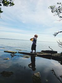 Full length of man standing on lake against sky