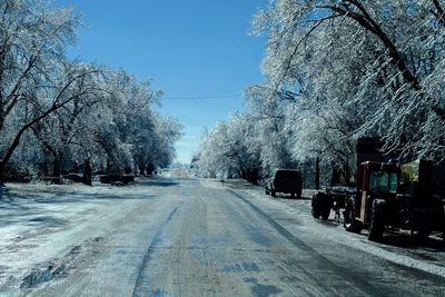 Car on snow covered trees against sky