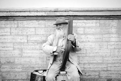 Full length portrait of man standing against wall