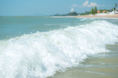 Waves splashing in sea against sky