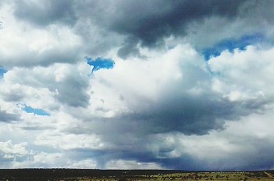 Scenic view of field against cloudy sky