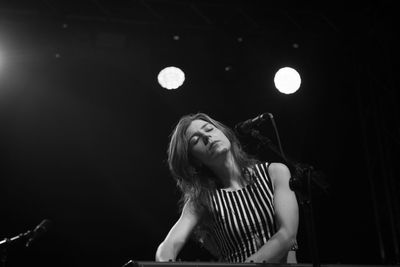 Full length of woman with illuminated lighting equipment