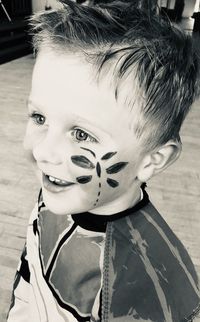 Cute boy with painted cheek at home