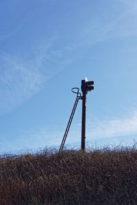 Windmill on field against blue sky