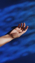 Close-up of woman hand on purple wall