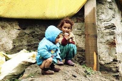 Portrait of young woman sitting on rock