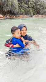 Father and son in water at park