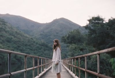 Man standing on footbridge