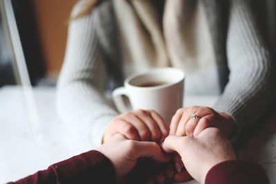 Midsection of man holding coffee cup