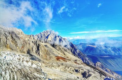 Scenic view of snowcapped mountains against blue sky