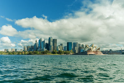 Sea by cityscape against sky