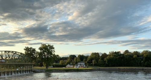 Scenic view of river by trees against sky