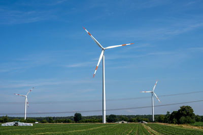 Wind turbines with power lines on a sunny day in germany
