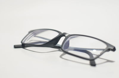 Close-up of eyeglasses on table against white background