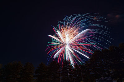 Low angle view of firework display against sky at night