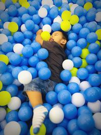 High angle view of baby boy enjoying in ball pool