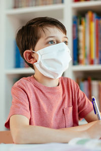 Portrait of boy on book at home