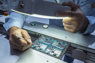 Midsection of man repairing electrical equipment