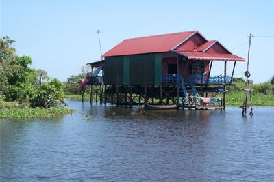 Houses by lake against clear sky