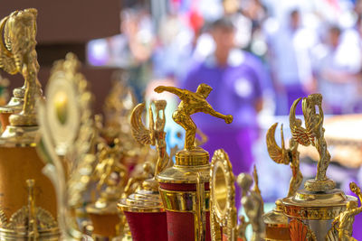 Close-up of golden trophies at store