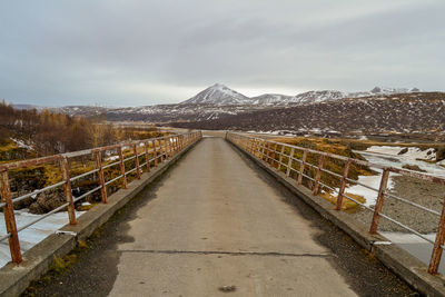 Road leading towards mountain against sky