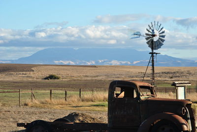 Traditional windmill on field against sky