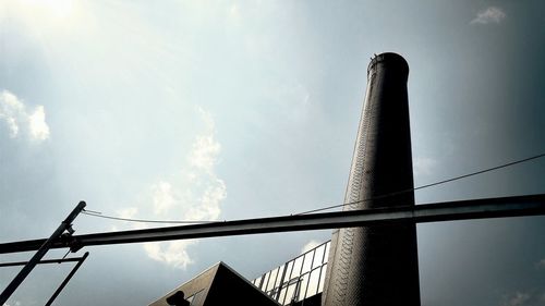 Low angle view of crane against cloudy sky