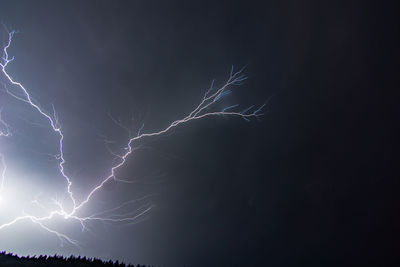 Low angle view of lightning against sky at night