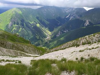 Scenic view of valley and mountains against sky