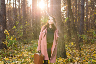 Young woman standing in forest