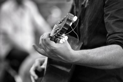 Midsection of man playing guitar