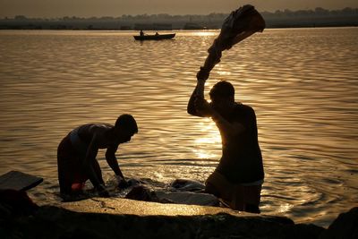 People washing cloths on riverbank 