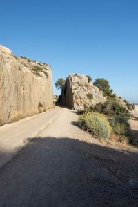 Road amidst rocks against clear sky