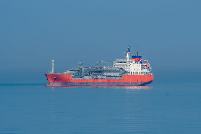 Ship in sea against clear blue sky