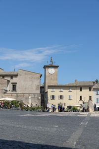 Buildings in city against blue sky