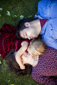 Young couple kissing daughter on grass in detroit mi