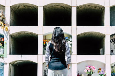 Rear view of woman standing by window