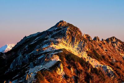 Snow capped mountain peak under sunrise