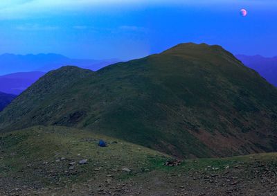 Scenic view of mountains against blue sky