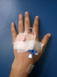 Cropped hand with iv drip on bed in hospital