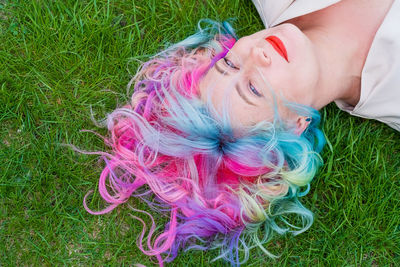 High angle view of young woman lying on grass