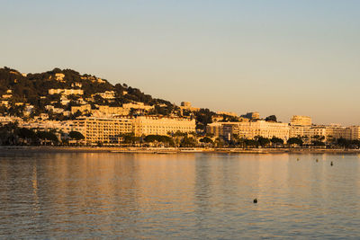 View of townscape by sea against clear sky